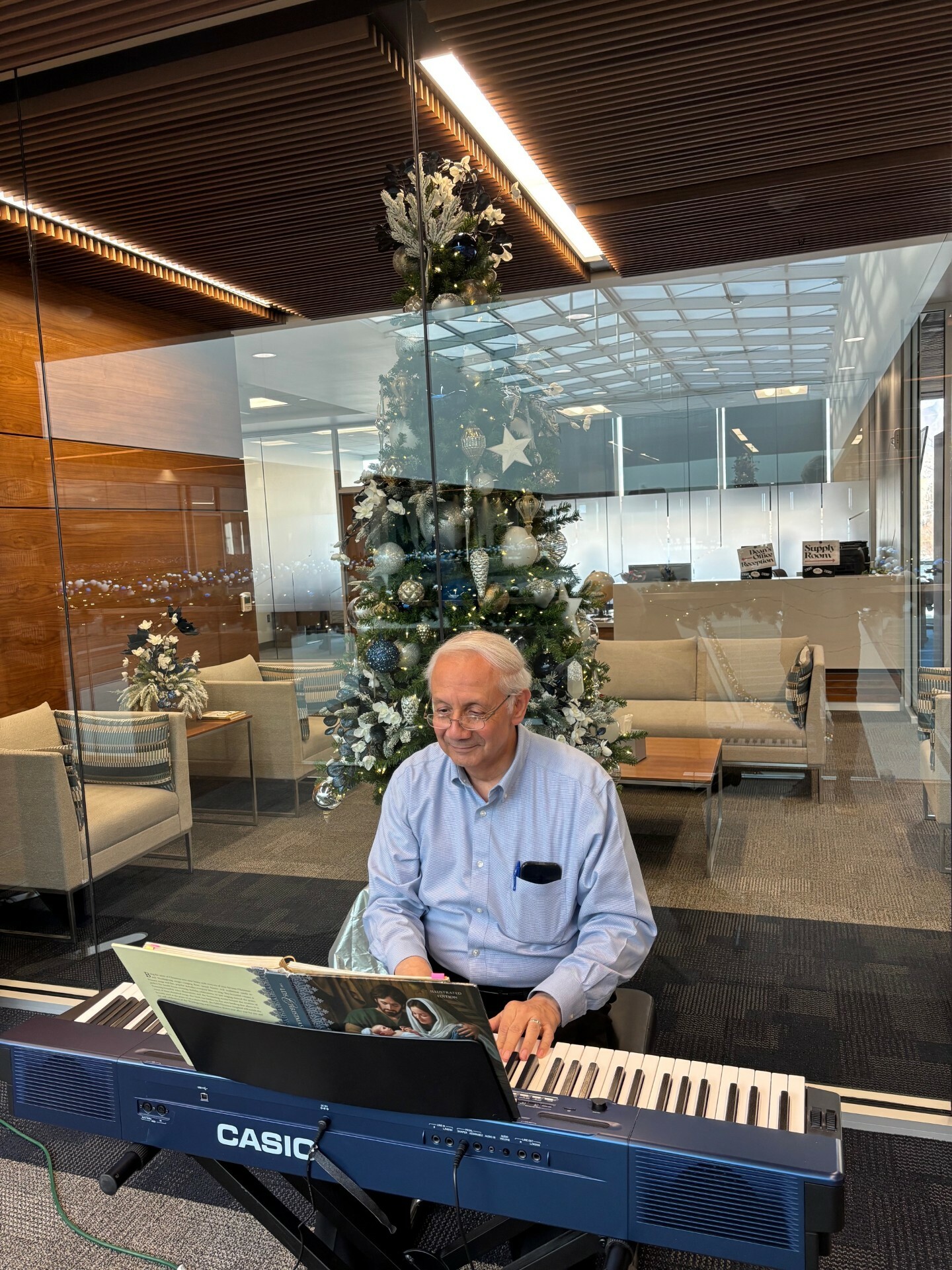 George Monsavias plays the piano in front of the Deans Office